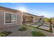 Landscaped backyard with gravel, covered patio, green shrubs, and view of neighboring homes at 19045 N 269Th Dr, Buckeye, AZ 85396
