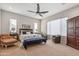 Spacious bedroom featuring a ceiling fan, carpet flooring, and sitting area near large windows at 19045 N 269Th Dr, Buckeye, AZ 85396