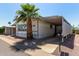 Charming single-story home featuring large windows, a covered carport, a driveway and a beautifully landscaped yard with a mature palm tree at 205 S Higley Rd # 300, Mesa, AZ 85206
