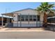Charming single-story home featuring large windows, a covered carport, and a beautifully landscaped yard with a mature palm tree at 205 S Higley Rd # 300, Mesa, AZ 85206
