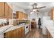 Functional kitchen area featuring wood cabinetry, tile backsplash, modern appliances, and hardwood flooring at 205 S Higley Rd # 300, Mesa, AZ 85206