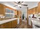 Well-lit kitchen with stainless steel appliances, wood cabinetry, mosaic backsplash, and durable hardwood floors at 205 S Higley Rd # 300, Mesa, AZ 85206