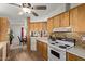 Open kitchen featuring white countertop, wood cabinets, appliances, mosaic backsplash and hardwood floors at 205 S Higley Rd # 300, Mesa, AZ 85206