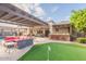 Outdoor living with pergola, putting green, bar, and plush seating creates an inviting space for relaxation and entertainment at 21231 E Nightingale Rd, Queen Creek, AZ 85142