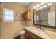 Neutral toned bathroom with a framed mirror, toilet, vanity, and tiled shower at 21231 E Nightingale Rd, Queen Creek, AZ 85142