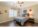 Neutral-toned bedroom with a bed, wood floors, ceiling fan, and window at 21231 E Nightingale Rd, Queen Creek, AZ 85142