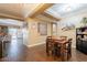 Open-concept dining area with wood-look tile flooring, beams, and views of the backyard at 21231 E Nightingale Rd, Queen Creek, AZ 85142
