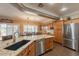 Open kitchen with granite counters, stainless appliances, wood cabinets and breakfast bar at 21231 E Nightingale Rd, Queen Creek, AZ 85142