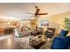 Open-concept living room with wood floors, a ceiling fan, and an adjacent kitchen and dining area at 21231 E Nightingale Rd, Queen Creek, AZ 85142