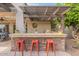 Outdoor bar featuring stone accents, bar seating, and space for grilling and enjoying refreshments at 21231 E Nightingale Rd, Queen Creek, AZ 85142