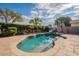 Sparkling pool with a slide and basketball hoop, surrounded by lush landscaping and stone patio, perfect for summer fun at 21231 E Nightingale Rd, Queen Creek, AZ 85142