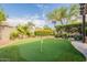 Manicured putting green in a beautifully landscaped backyard, ideal for practicing your short game and outdoor enjoyment at 21231 E Nightingale Rd, Queen Creek, AZ 85142