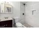 Bathroom featuring marble-look tile shower, dark vanity, and modern fixtures at 214 W June Cir, Mesa, AZ 85201