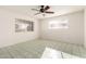 Bright bedroom with tile floors, ceiling fan, and two windows, offering ample natural light at 214 W June Cir, Mesa, AZ 85201