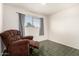 A cozy bedroom with a window and an accent chair at 214 W June Cir, Mesa, AZ 85201