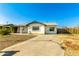 Welcoming single-story home showcasing a covered porch, xeriscaped yard, and a well-kept driveway at 214 W June Cir, Mesa, AZ 85201
