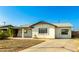 Single-story house with a covered porch, xeriscaped yard, and mature vines, adding to its curb appeal at 214 W June Cir, Mesa, AZ 85201