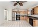 Bright kitchen features a stainless refrigerator, black range, and light wood cabinets and white tile flooring at 214 W June Cir, Mesa, AZ 85201