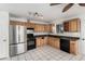 Spacious kitchen featuring stainless steel refrigerator and black oven with light wood cabinetry at 214 W June Cir, Mesa, AZ 85201