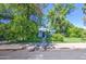 A single-story home with charming blue accents framed by mature trees and lush greenery at 220 E 14Th St, Tempe, AZ 85281