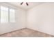 A bright and airy bedroom with neutral carpet, a large window, and a ceiling fan at 3016 N 109Th Ave, Avondale, AZ 85392