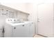 This is a bright laundry room with a washer and dryer with shelving and a door to the outside at 3016 N 109Th Ave, Avondale, AZ 85392