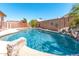 An inviting backyard pool with rock features and decor surrounded by a block fence and trees at 3016 N 109Th Ave, Avondale, AZ 85392