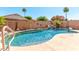 A captivating backyard pool with rock features and decor surrounded by palm trees and lush foliage at 3016 N 109Th Ave, Avondale, AZ 85392