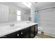 Bathroom featuring a double vanity, a blue shower curtain, and neutral colored tile flooring at 3436 E Gary Way, Gilbert, AZ 85234