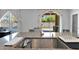 Kitchen island with sink featuring stainless fixtures and view of outdoor pool at 3436 E Gary Way, Gilbert, AZ 85234