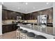 Well-lit kitchen with granite island, stainless appliances, and dark wood cabinetry at 3436 E Gary Way, Gilbert, AZ 85234
