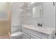 Bright bathroom with a white vanity, framed mirror, and tiled shower at 3823 W Berridge Ln, Phoenix, AZ 85019