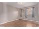 Bedroom with wood-look flooring, gray walls, and natural light from two windows at 3823 W Berridge Ln, Phoenix, AZ 85019