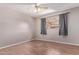 Neutral bedroom with a ceiling fan, window and wood look floors at 3823 W Berridge Ln, Phoenix, AZ 85019