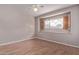 An empty bedroom with a window and wood look floors at 3823 W Berridge Ln, Phoenix, AZ 85019