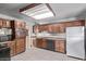 Well-lit kitchen featuring wood cabinets, a refrigerator, wood look floors and an attached dining area at 3823 W Berridge Ln, Phoenix, AZ 85019