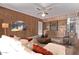 Comfortable living room features wood-paneled walls, ceiling fan, a white couch and a large built-in bookcase at 3823 W Berridge Ln, Phoenix, AZ 85019