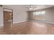 Spacious, empty living room features a ceiling fan, a window and wood look floors at 3823 W Berridge Ln, Phoenix, AZ 85019