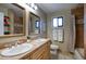 Bathroom with double vanity, framed mirrors, adjacent toilet and shower with white towels at 4008 N 85Th St, Scottsdale, AZ 85251