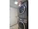 Bright laundry room features a stacked washer and dryer with an adjacent white door at 4008 N 85Th St, Scottsdale, AZ 85251