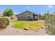 The backyard features a manicured lawn, desert landscaping, and a covered patio at 4100 S Dewdrop Ct, Gilbert, AZ 85297