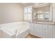 Bathroom featuring a soaking tub, granite counter, and ample natural light at 4100 S Dewdrop Ct, Gilbert, AZ 85297