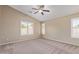 Bedroom featuring neutral walls, plush carpet, plantation shutters, and a ceiling fan at 4100 S Dewdrop Ct, Gilbert, AZ 85297