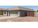 Single-story home with desert landscaping, stone accents, two-car garage, gated side yard, and neutral color scheme at 4100 S Dewdrop Ct, Gilbert, AZ 85297