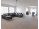 Bright living room featuring neutral walls, plush carpeting, and a comfortable sectional sofa at 44147 W Snow Dr, Maricopa, AZ 85138