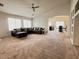 Open concept living room featuring a large sectional couch and seamless flow to dining area at 44147 W Snow Dr, Maricopa, AZ 85138