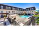 Community pool area surrounded by townhomes, featuring lounge chairs and a pergola at 4438 N 27Th St # 27, Phoenix, AZ 85016