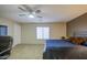 Large primary bedroom with carpet, ceiling fan, TV, and cozy bed at 46057 W Dutchman Dr, Maricopa, AZ 85139