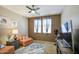 Cozy bedroom featuring an oversized chair, TV, and ceiling fan at 46057 W Dutchman Dr, Maricopa, AZ 85139