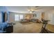 A spacious bonus room with carpet, large windows, a ceiling fan, and comfortable seating at 46057 W Dutchman Dr, Maricopa, AZ 85139